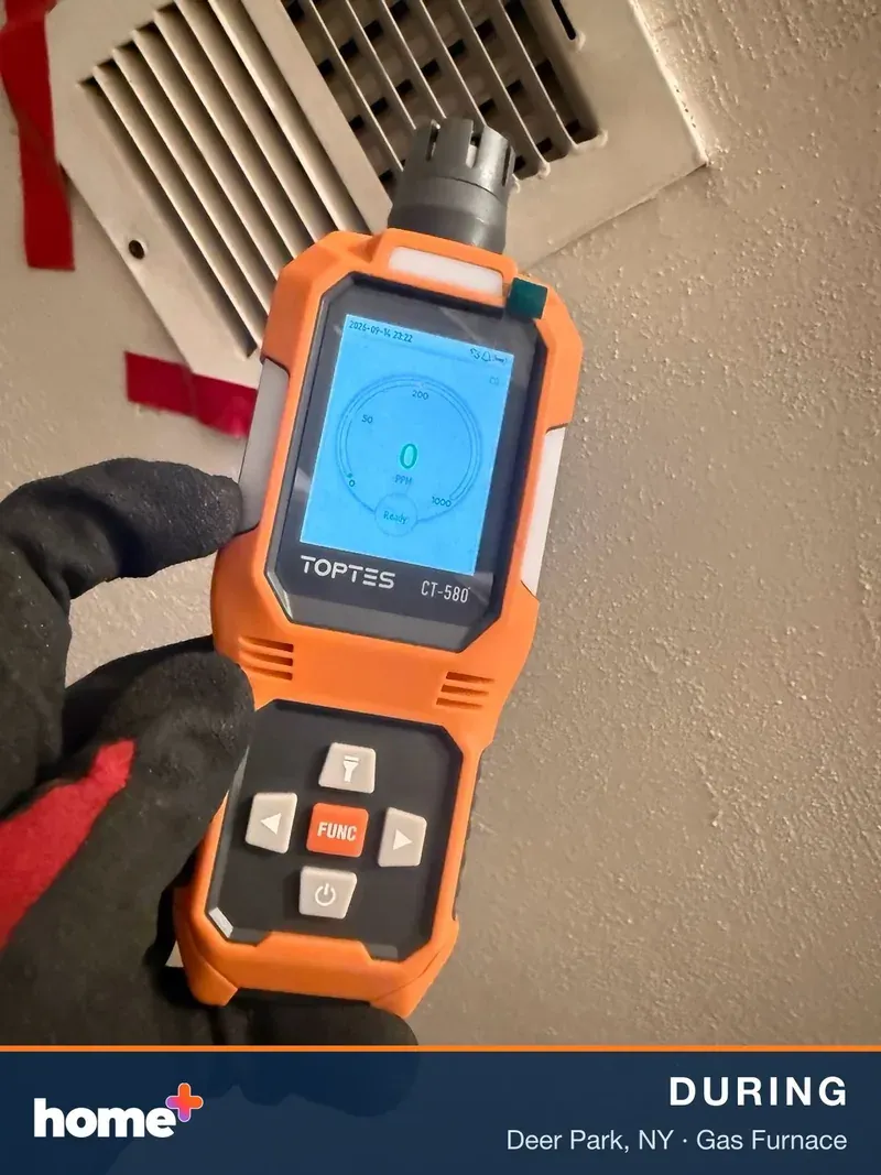 A gloved hand holds an orange TOPTEST CT-580 diagnostic device showing a CO reading of 0 PPM, with a white air vent in the background.