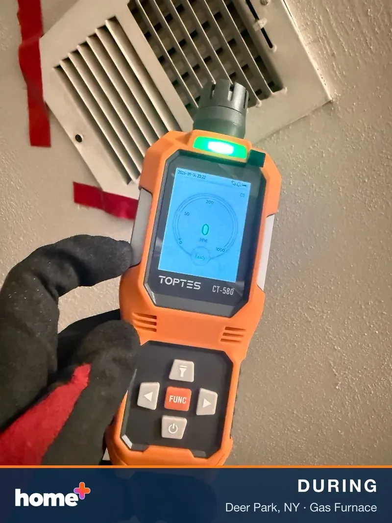 A gloved hand holds an orange TOPTEST CT-580 diagnostic device with a green light on top, displaying a CO reading of 0 PPM.