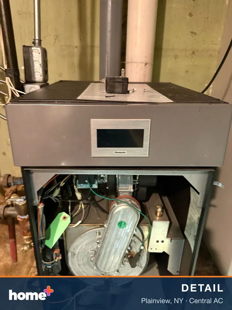 Close-up view of an open indoor HVAC unit, revealing its internal components and a digital screen.